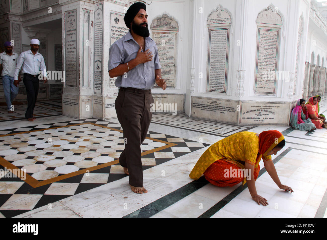 Pèlerins sikhs prier sur le Golden Temple, Amritsar, Inde Banque D'Images