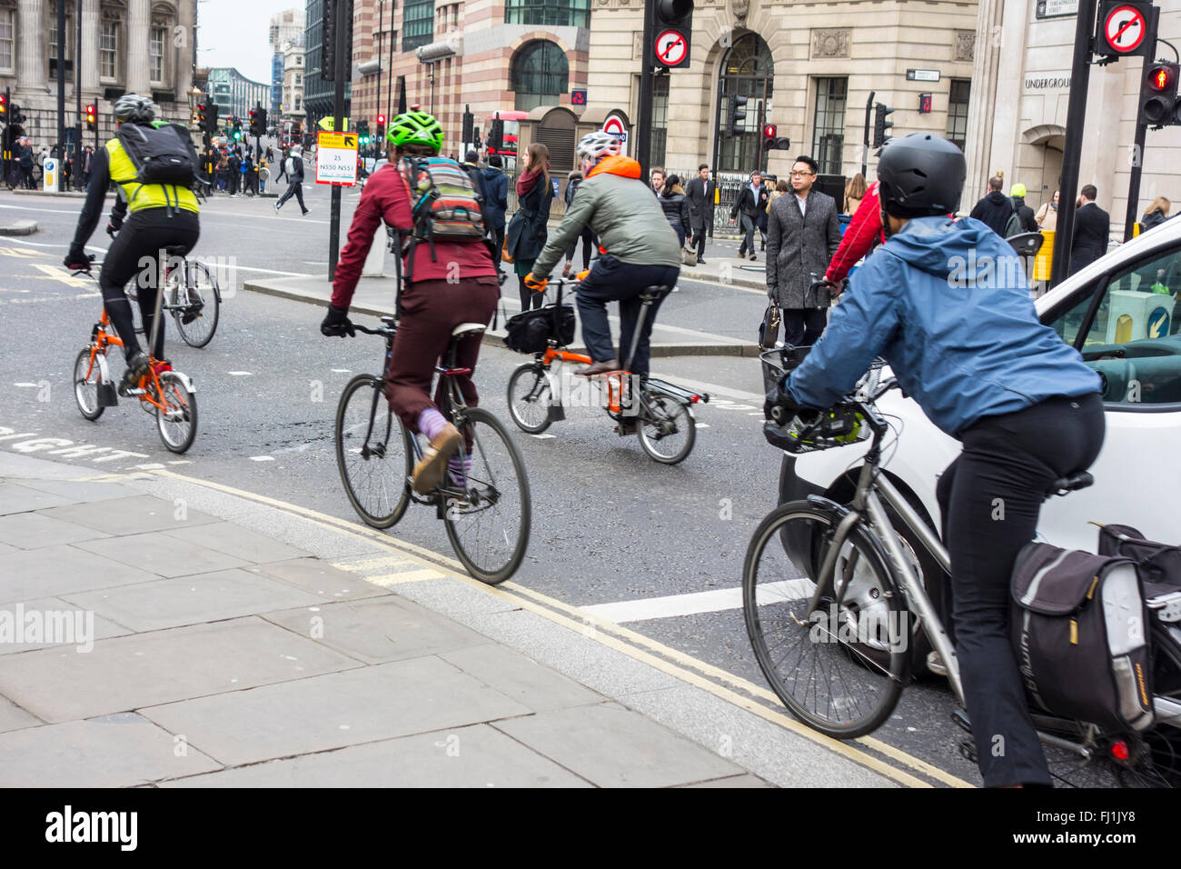 Les cyclistes de rouler à partir de feux de circulation à la sortie de la Banque mondiale, Londres, UK Banque D'Images