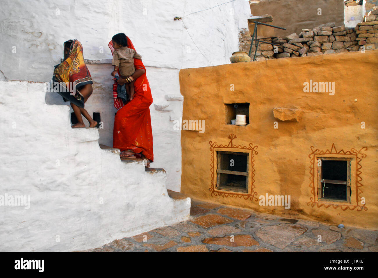 Femme à monter les escaliers d'une maison traditionnelle dans le fort de Jaisalmer, Inde Banque D'Images