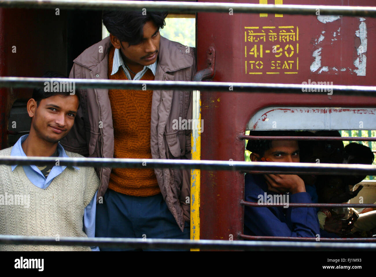 Les passagers d'une fenêtre de train indien Banque D'Images