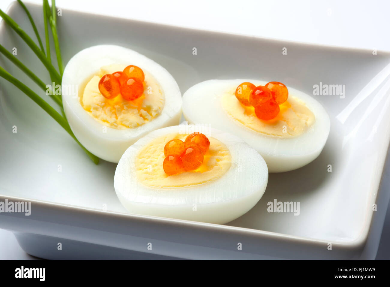 Oeufs de caille à la coque avec des oeufs de truite et ciboulette sur un plat Banque D'Images