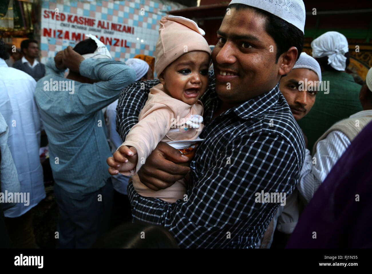 Père musulman et fils pleurer dans la foule à Nizamuddin Dargah , Delhi Banque D'Images