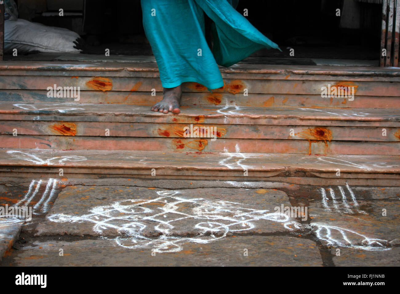 Rangoli sur le terrain et portant à Lungi Madurai, Inde Banque D'Images