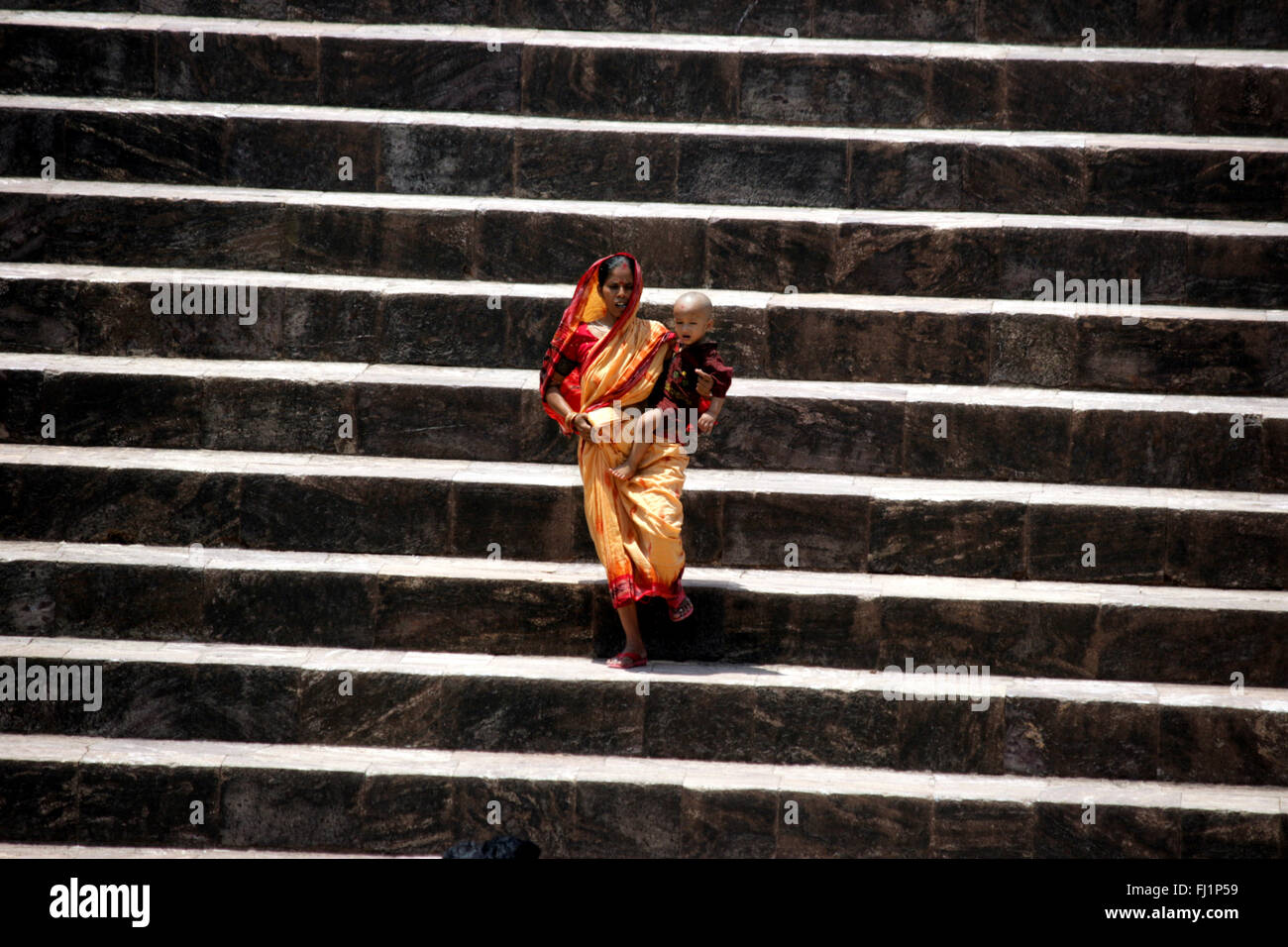 Femme portant son bébé sur les marches de Konark temple, Orissa, Inde Banque D'Images