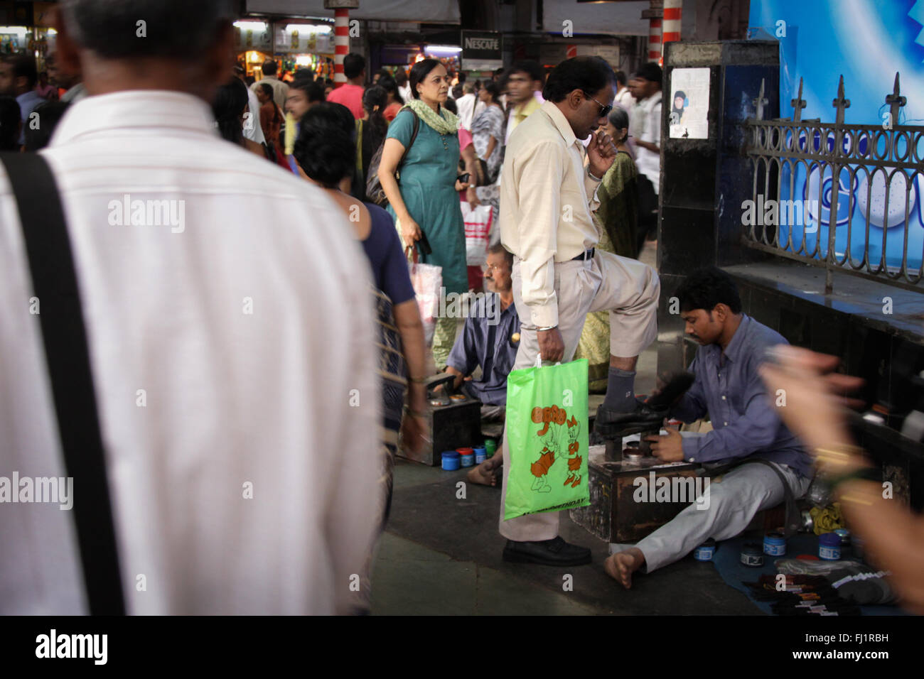Polisseur de chaussures à Victoria CST terminal, Mumbai Banque D'Images