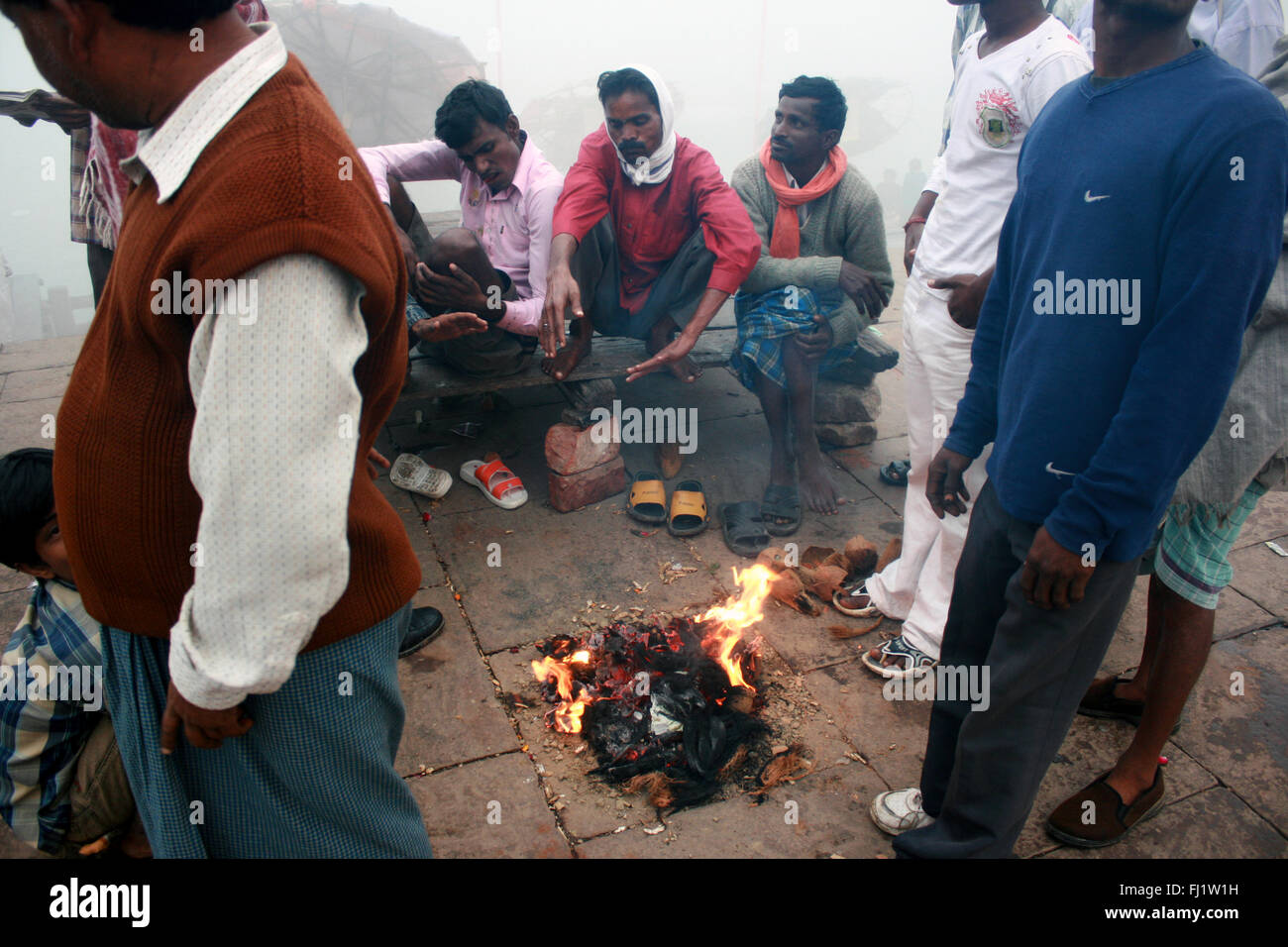 Pèlerins hindous faisant feu sur un ghat de Varanasi , Inde Banque D'Images