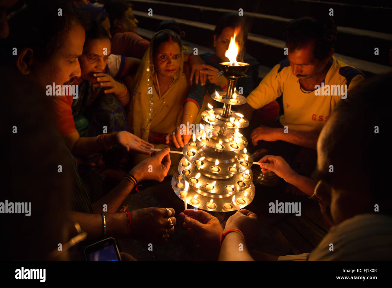 Pèlerins hindous allumant des bougies sur un ghat de Varanasi, Inde Banque D'Images