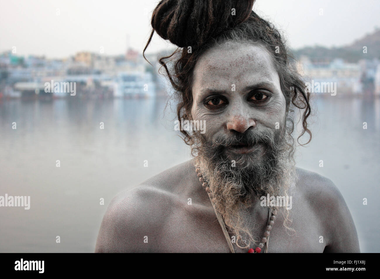 Naga sadhu saint homme devant le lac sacré de Pushkar, Rajasthan Banque D'Images