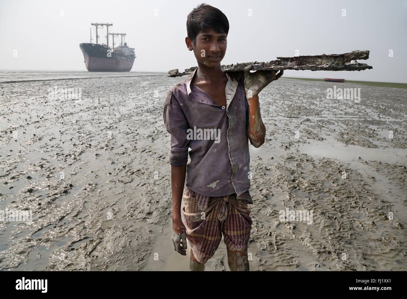 Enfant travaillant au chantier de démolition de navires dans la région de Chittagong au Bangladesh , Banque D'Images