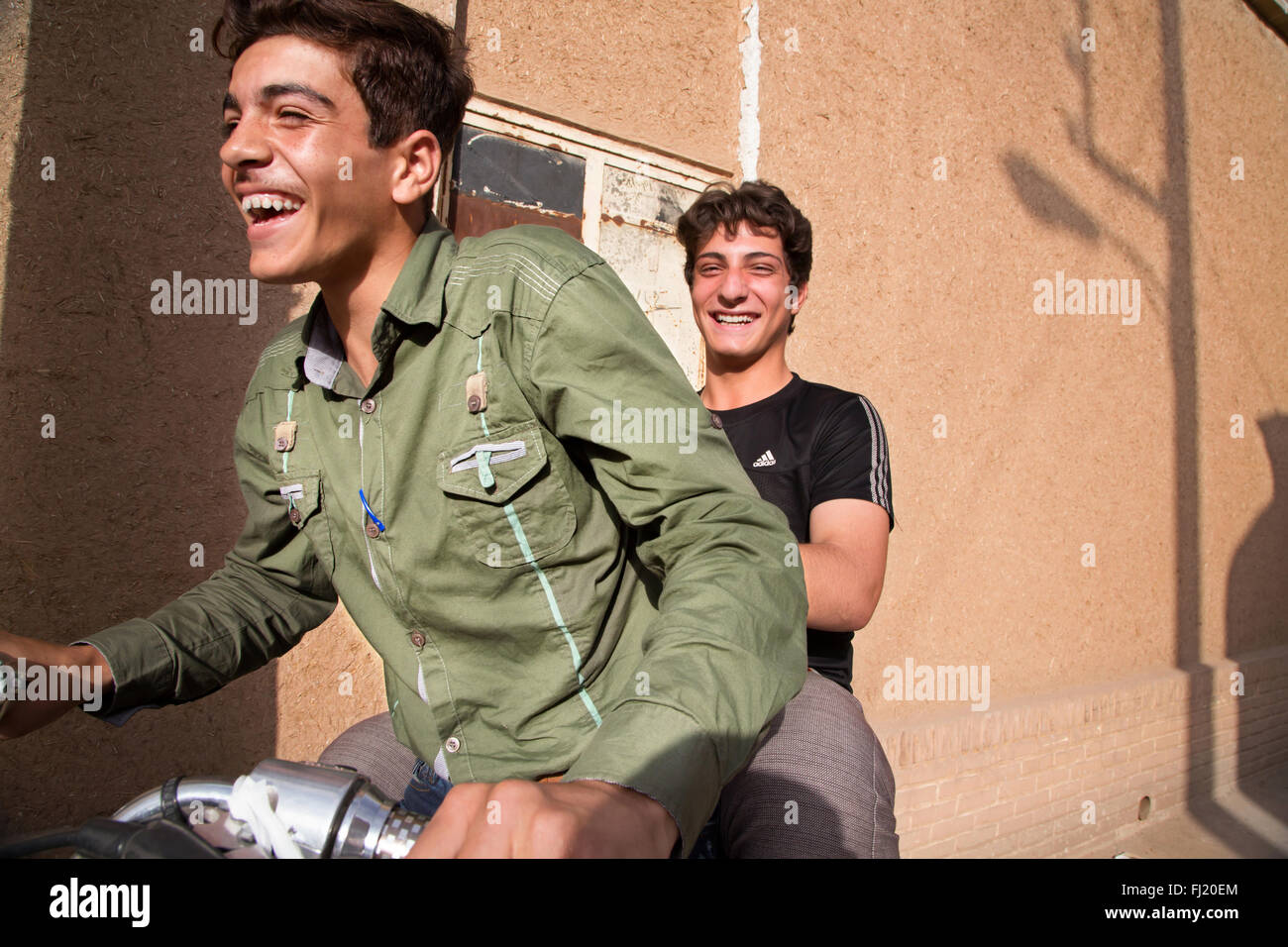 Les jeunes hommes iraniens s'amuser en moto dans les rues de Kashan Banque D'Images