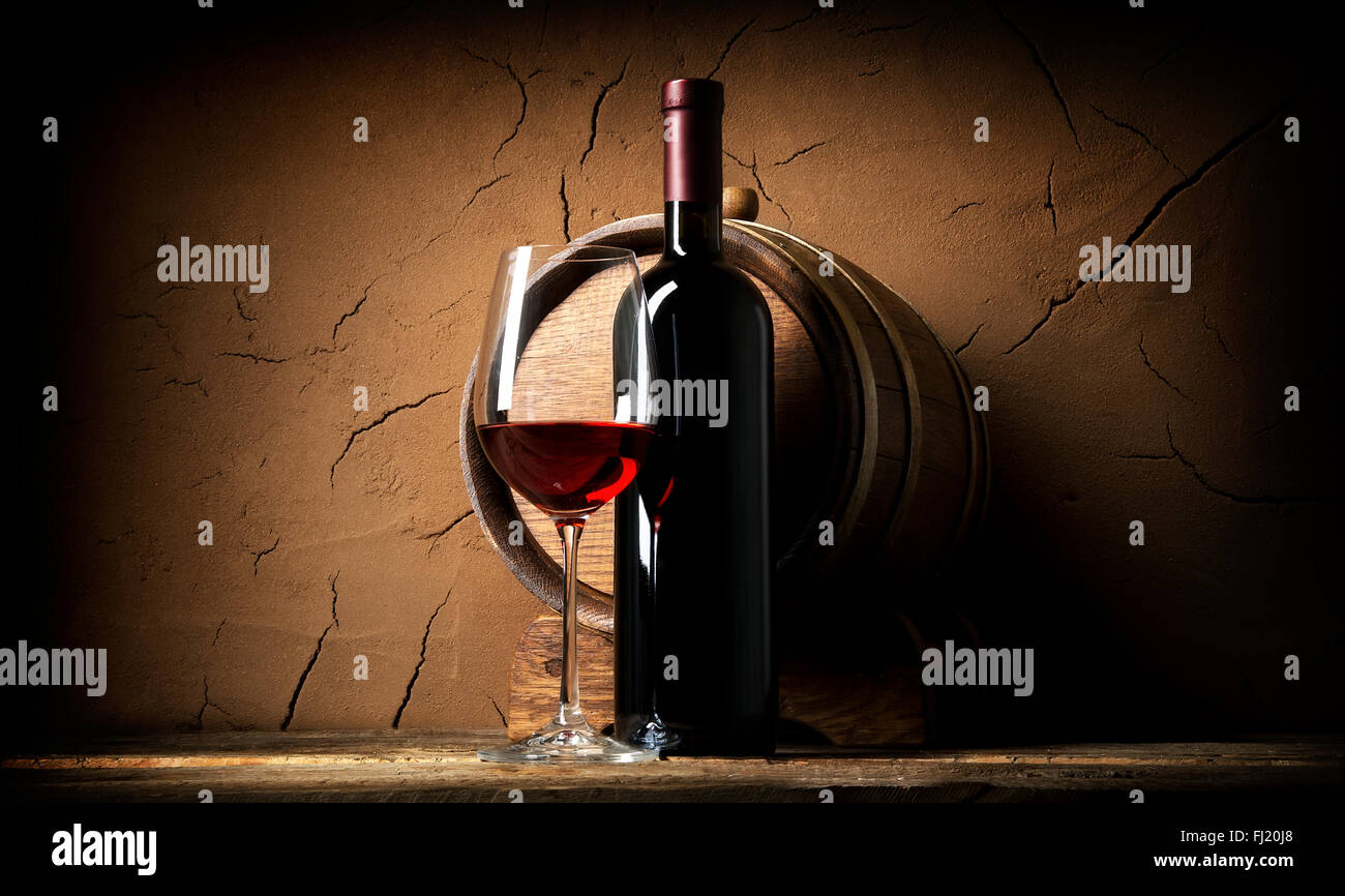 Vieux vin rouge en cave près de la paroi d'argile Banque D'Images