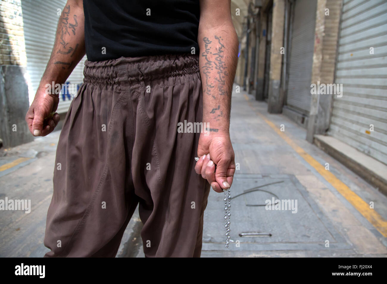 Un homme montre des tatouages sur ses bras écrit en persan dans le grand bazar de Téhéran, Iran Banque D'Images