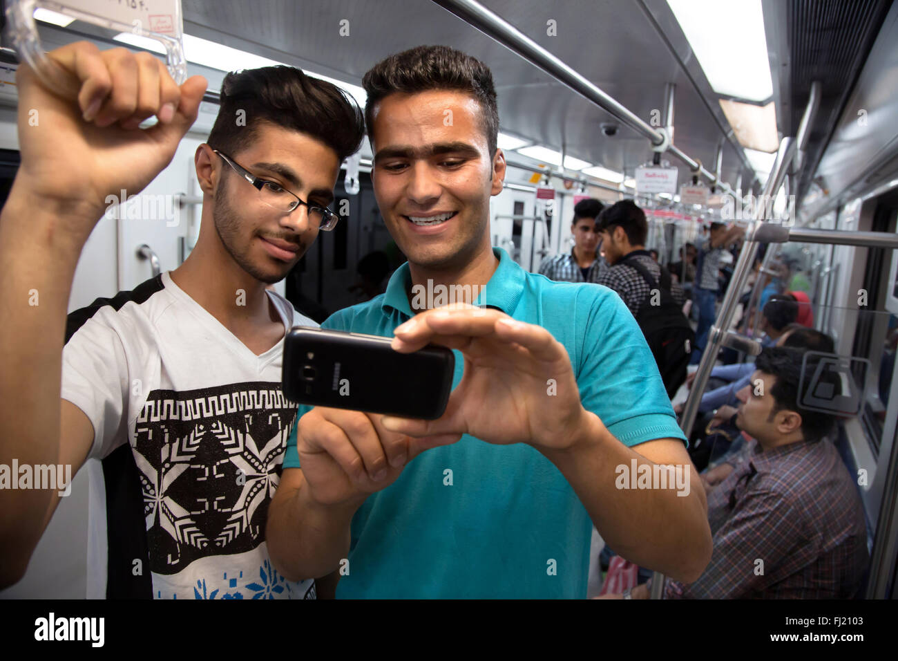 Deux jeunes hommes prennent des selfies téléphone dans le métro de Téhéran, Iran Banque D'Images