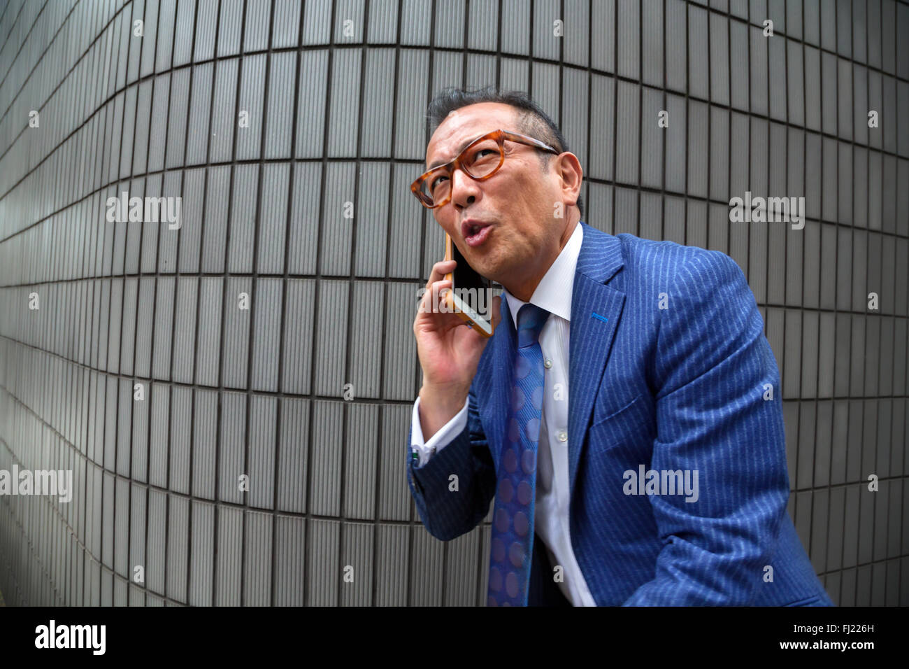 Homme d'affaires japonais sur le téléphone à Tokyo Banque D'Images