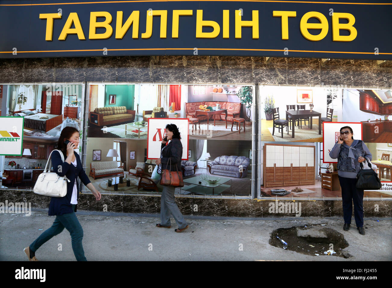 La femme marche dans les rues de Ulaanbatatr devant un magasin de meubles - la culture nomade Banque D'Images