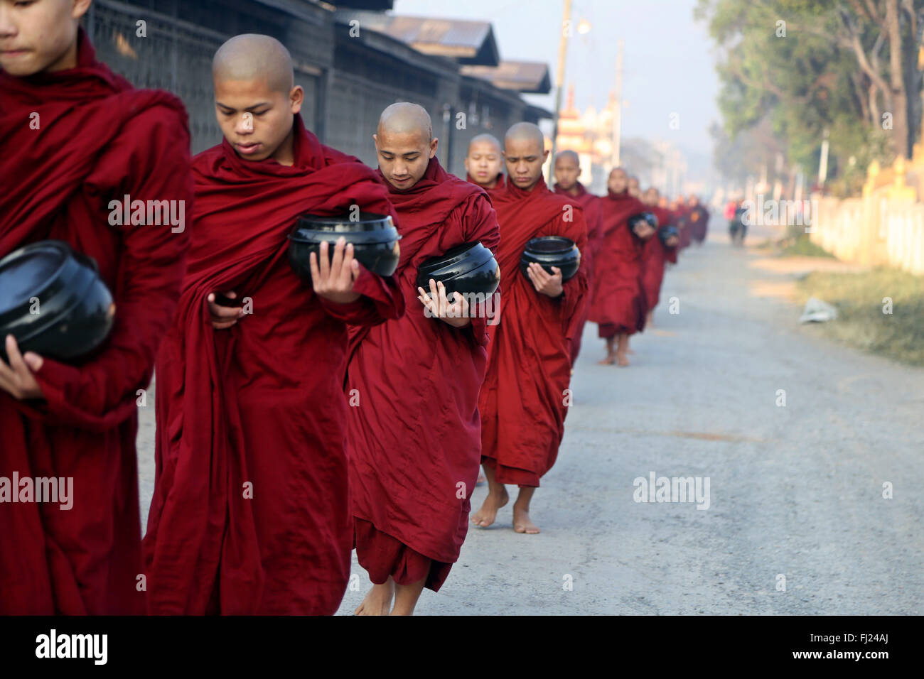 Les moines bouddhistes recevoir le riz de population, rituel quotidien, Nyaung-U, Myanmar Banque D'Images