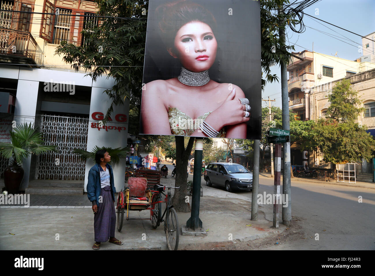 L'homme avec des publicité pour des bijoux dans une rue de Mandalay, Myanmar Banque D'Images