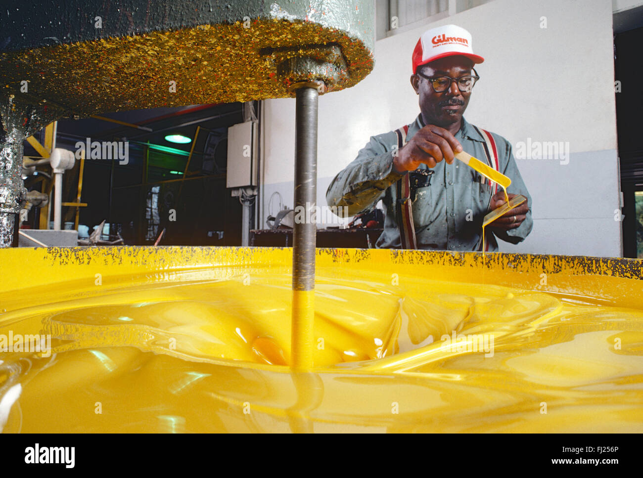 African American man de mélanger la peinture dans une usine industrielle Banque D'Images