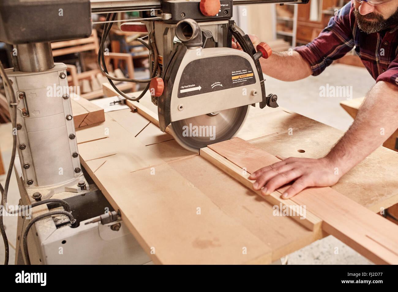 La scie circulaire à bras radial la découpe de planche en bois Photo
