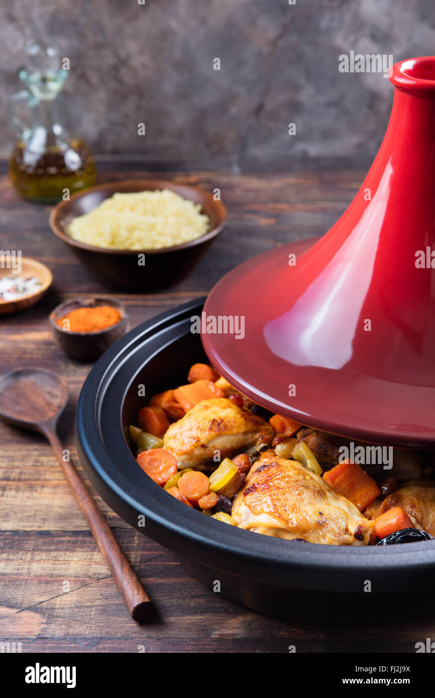 Tagine avec le poulet cuit et les légumes. Une cuisine traditionnelle marocaine. Fond de bois. Copy space Banque D'Images