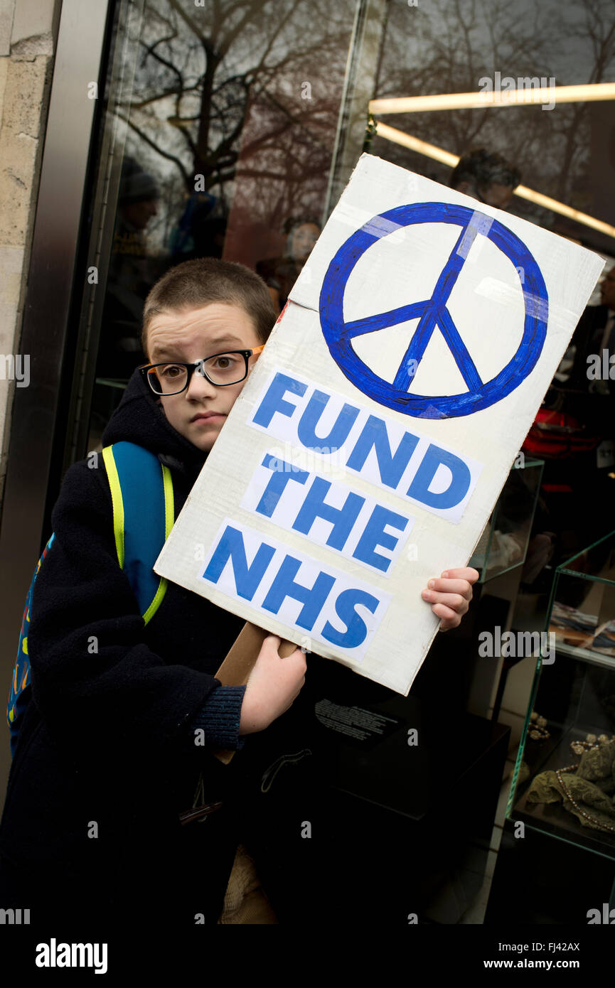 Trident Stop Manifestation organisée par la CND. Un jeune garçon tient une pancarte disant 'Fund the NHS' avec un symbole de la CND. Banque D'Images