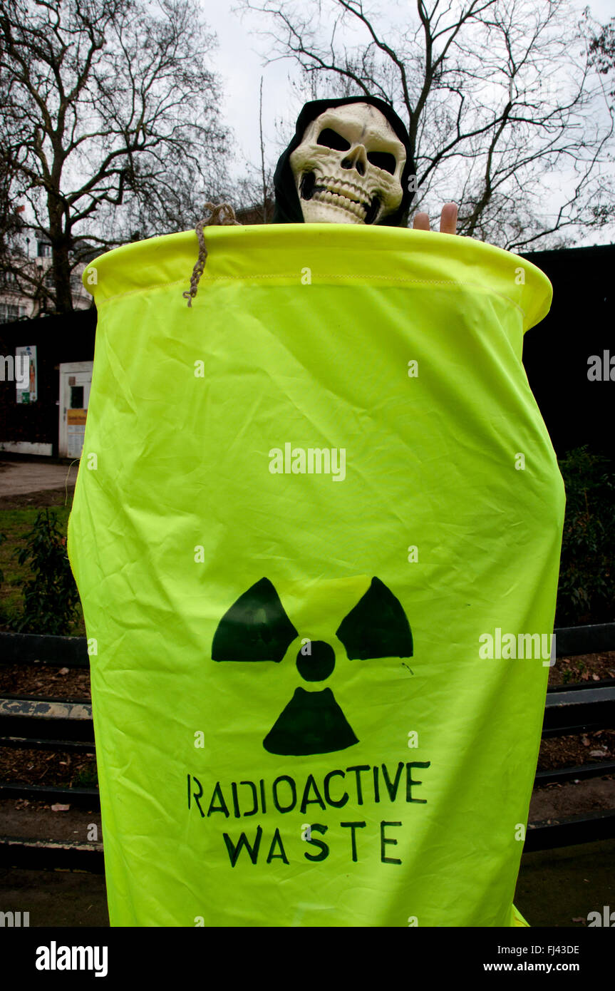 Trident Stop Manifestation organisée par la CND. Un militant portant un masque de squelette se trouve dans un sac en disant déchets radioactifs. Banque D'Images