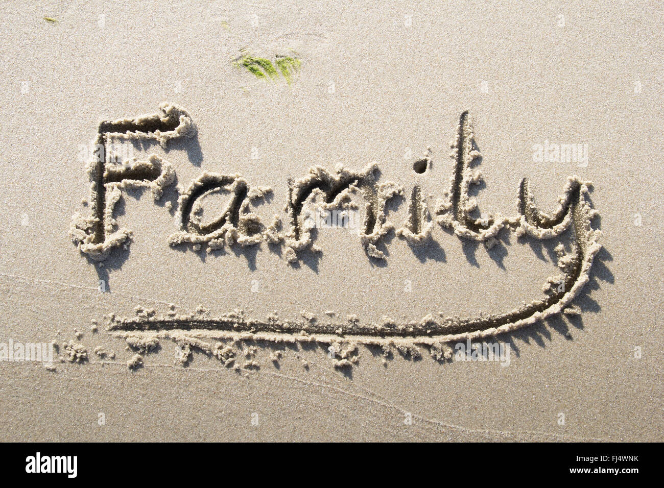 "Famille" écrit sur la plage de sable Banque D'Images