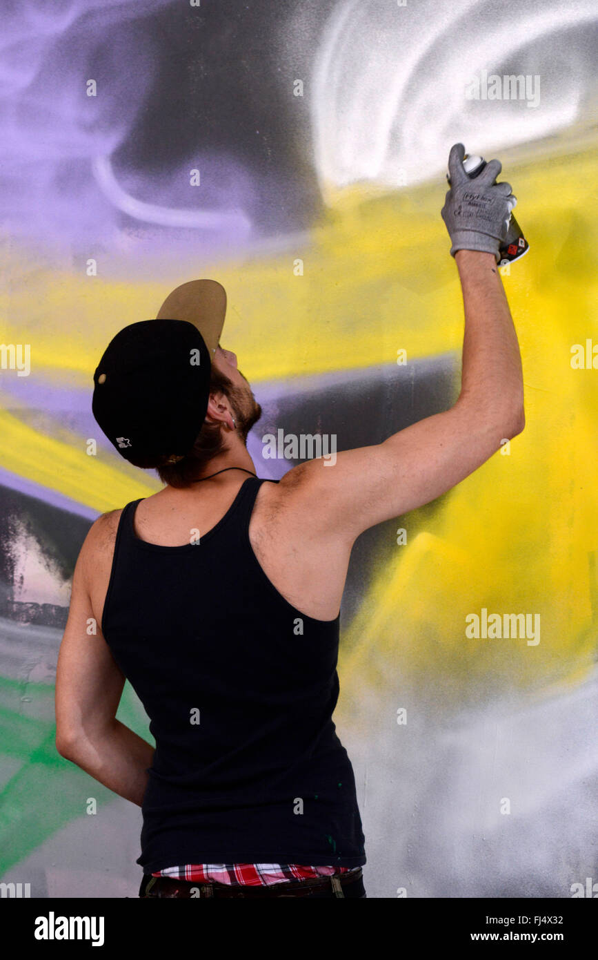 La pulvérisation de l'homme à un mur de graffiti dans un abandonend terre industrielle, l'Allemagne, en Rhénanie du Nord-Westphalie, Duesseldorf Banque D'Images