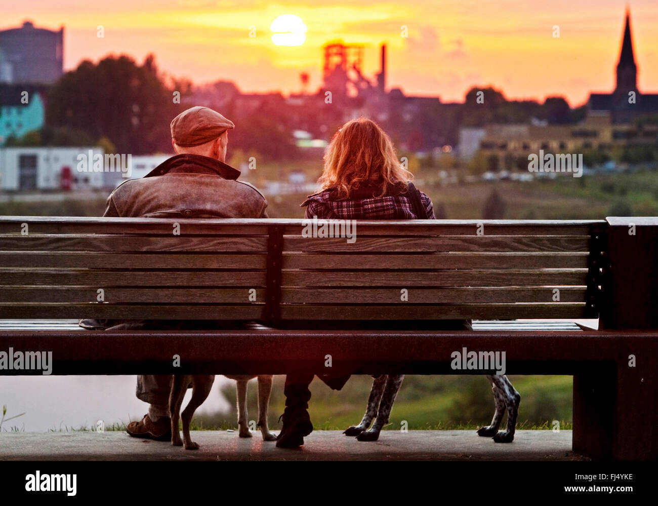 Deux personnes assises sur un banc de parc au lac Phoenix et profiter de la vue au coucher du soleil, de l'Allemagne, en Rhénanie du Nord-Westphalie, Ruhr, Dortmund Banque D'Images