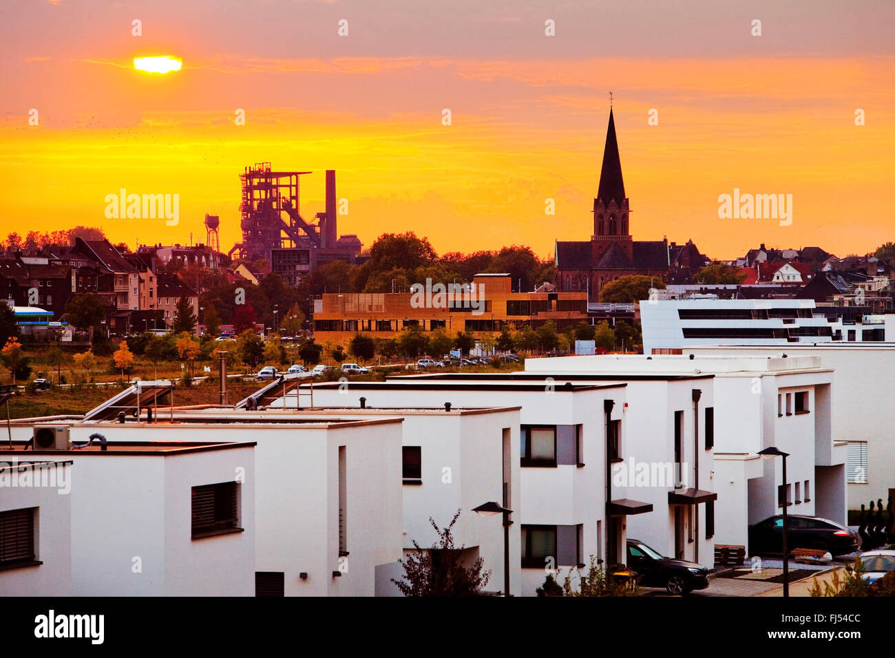 Nouveau quartier résidentiel au lac Phoenix au coucher du soleil, du haut fourneau et clocher en arrière-plan, l'Allemagne, en Rhénanie du Nord-Westphalie, Ruhr, Dortmund Banque D'Images