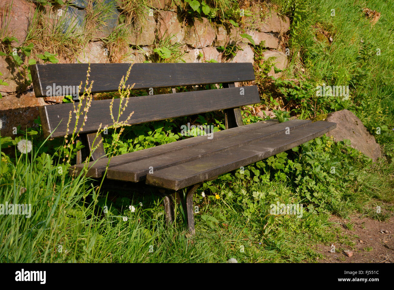 Banc en bois en face d'un mur de pierre, l'Allemagne, l'Odenwald Banque D'Images