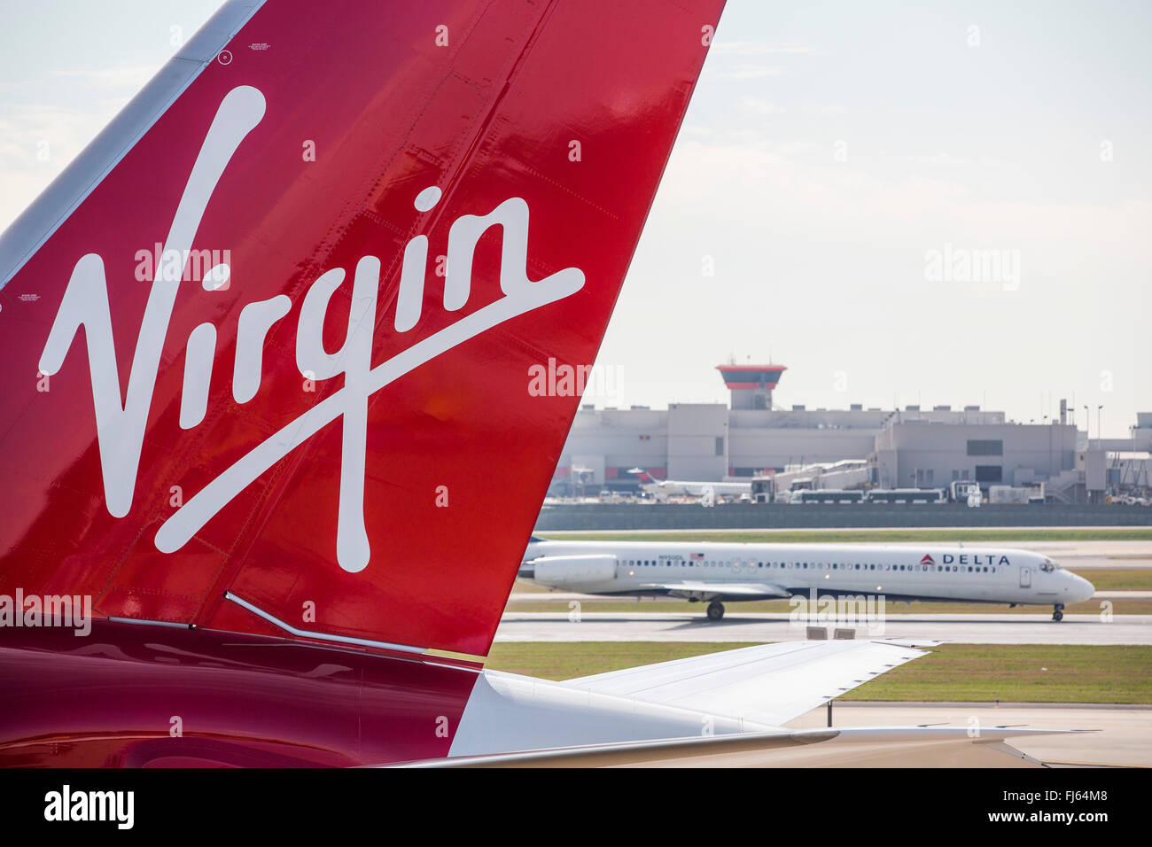 Une compagnie aérienne Delta avion atterrit derrière un avion Virgin Atlantic sur la piste de l'Hartsfield Jackson Atlanta International Airport. Banque D'Images