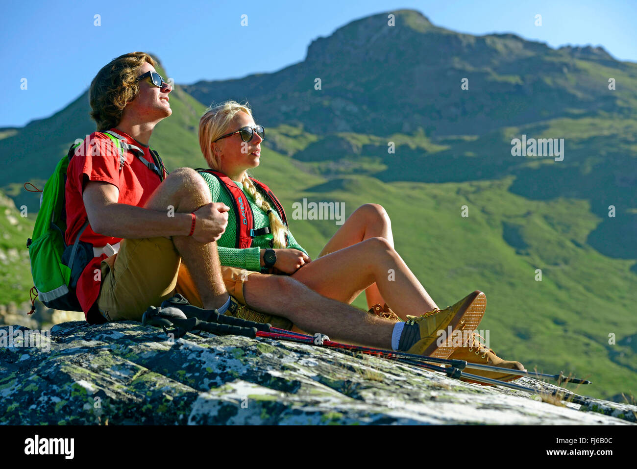 Deux randonneurs assis au soleil sur un rocher dans les Alpes, France, Savoie, Vanoise Nationalpark Banque D'Images