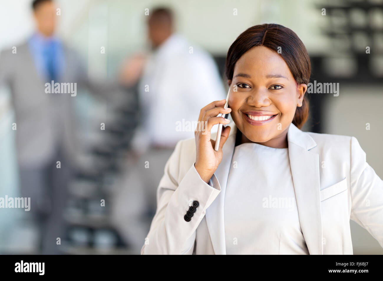 Belle jeune entrepreneur africain talking on cell phone Banque D'Images