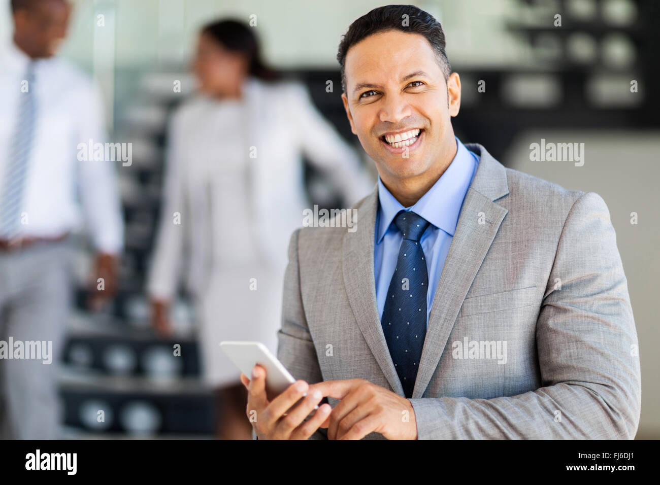Smiling middle aged businessman using smart phone Banque D'Images