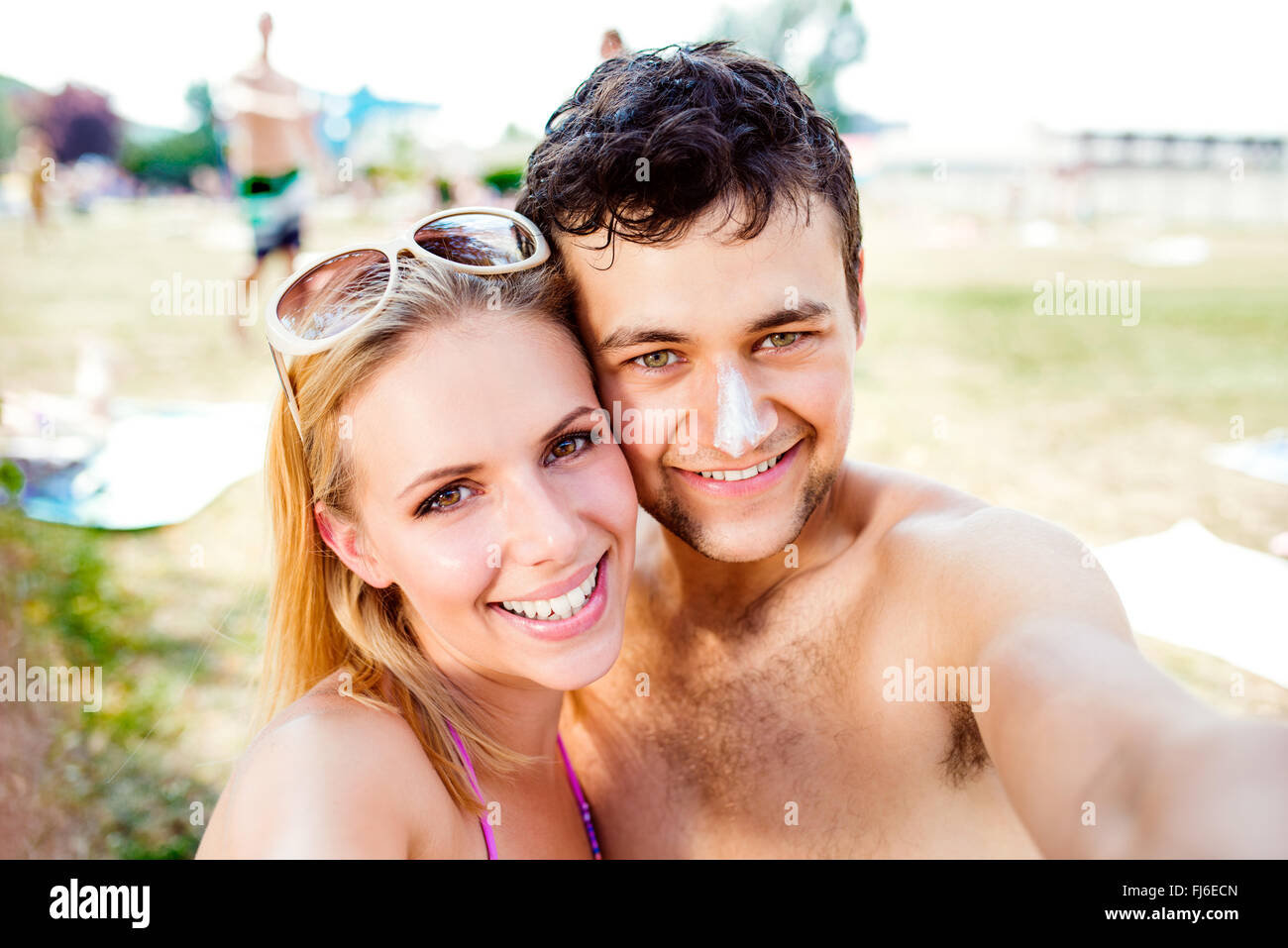 Jeune couple, en prenant un bain de soleil. selfies L'écran solaire sur le nez. Banque D'Images