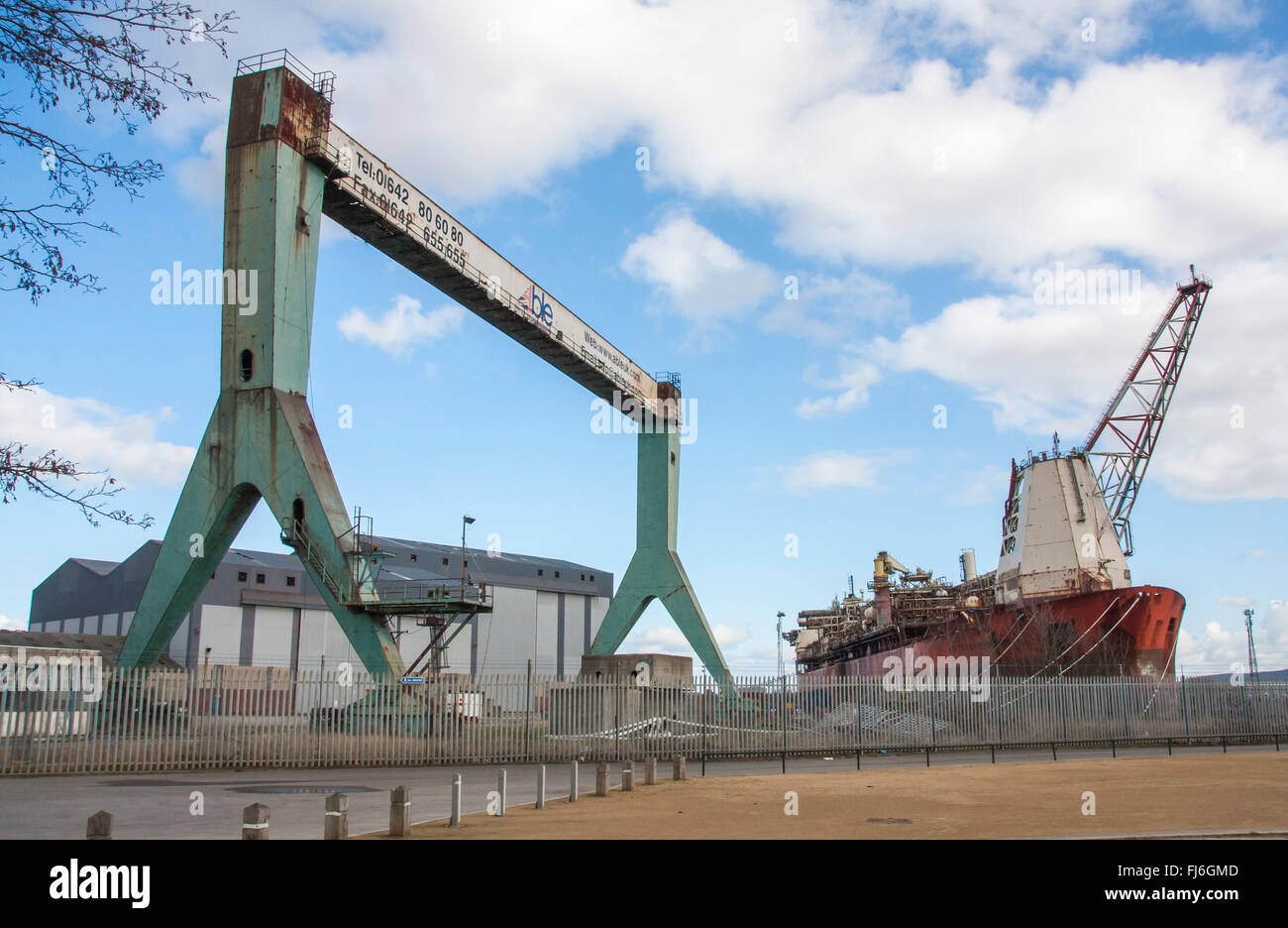 Une vue de l'Middlehaven dockland site à Middlesbrough montrant une grue industrielle et de la mer du Nord l'huile producteur navire. Banque D'Images