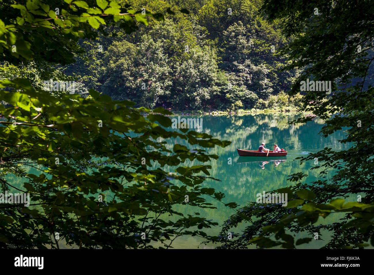 Petit bateau en bois avec deux personnes à la forest lake Banque D'Images
