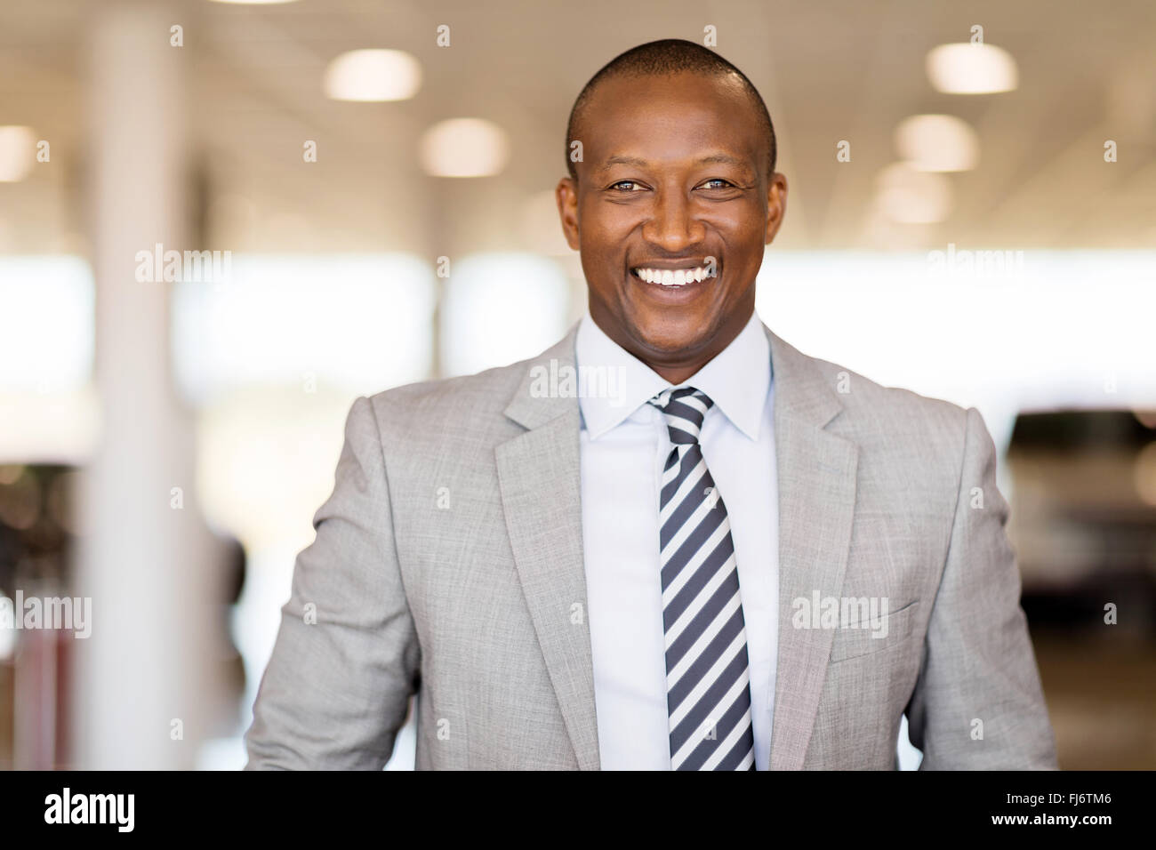 L'Afrique de l'heureux vendeur de voiture en showroom Banque D'Images
