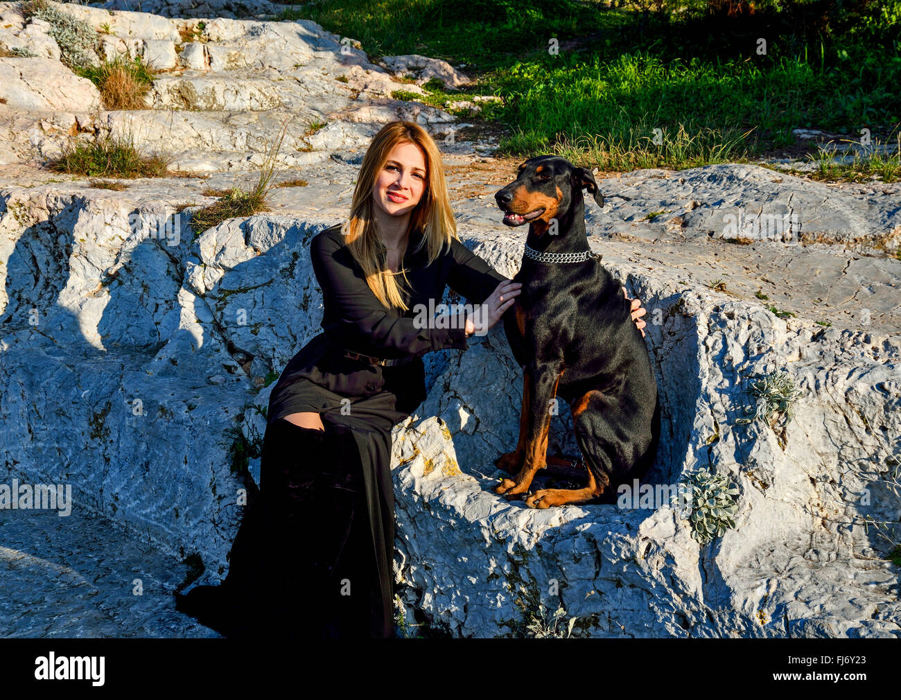 Modèle féminin posant avec Doberman Banque D'Images