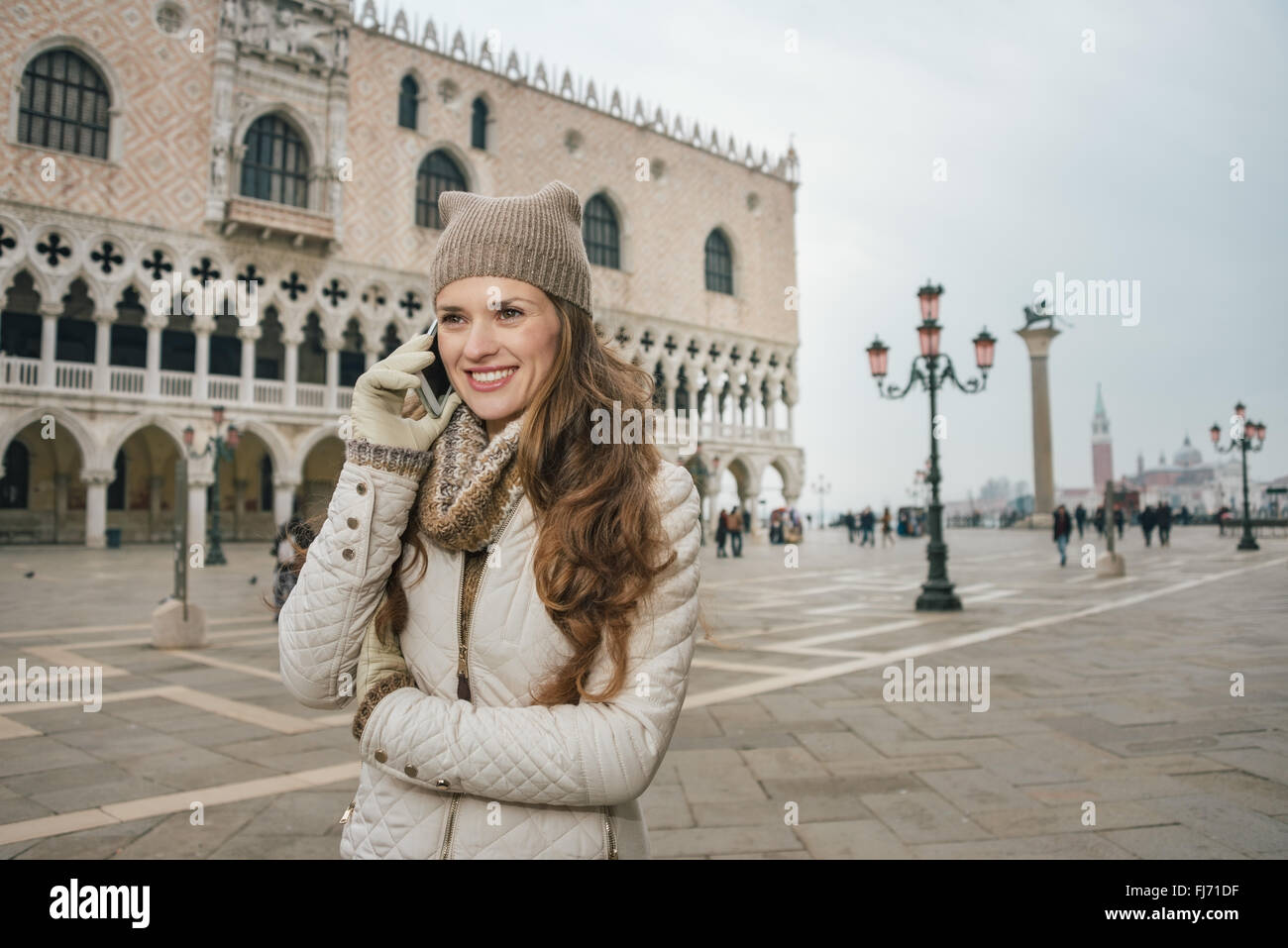 Venise, Italie charmant peut aider à tirer le meilleur parti de votre prochaine escapade d'hiver. Happy young woman talking cell phone touristiques sur St. Banque D'Images