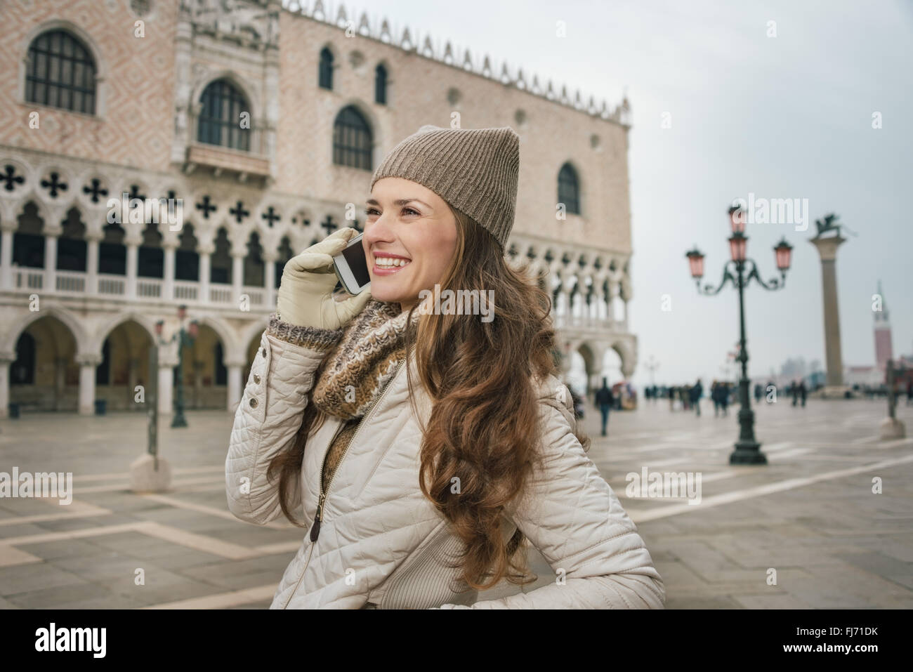 Venise, Italie charmant peut aider à tirer le meilleur parti de votre prochaine escapade d'hiver. Smiling young woman talking cell phone touristiques sur S Banque D'Images