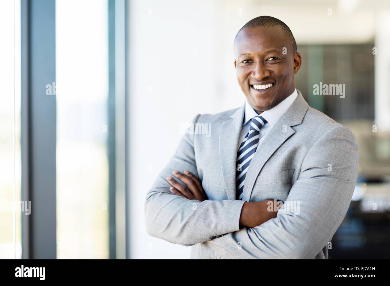 Cheerful African American office worker with arms folded Banque D'Images