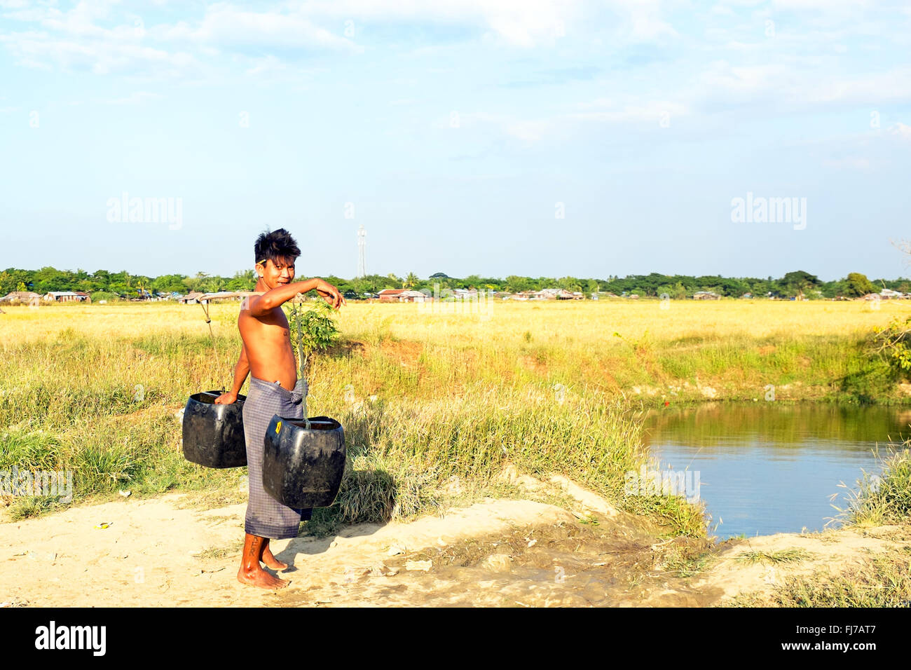 Porteur d'eau avec deux seaux obtenir de l'eau dans la campagne du Myanmar Banque D'Images
