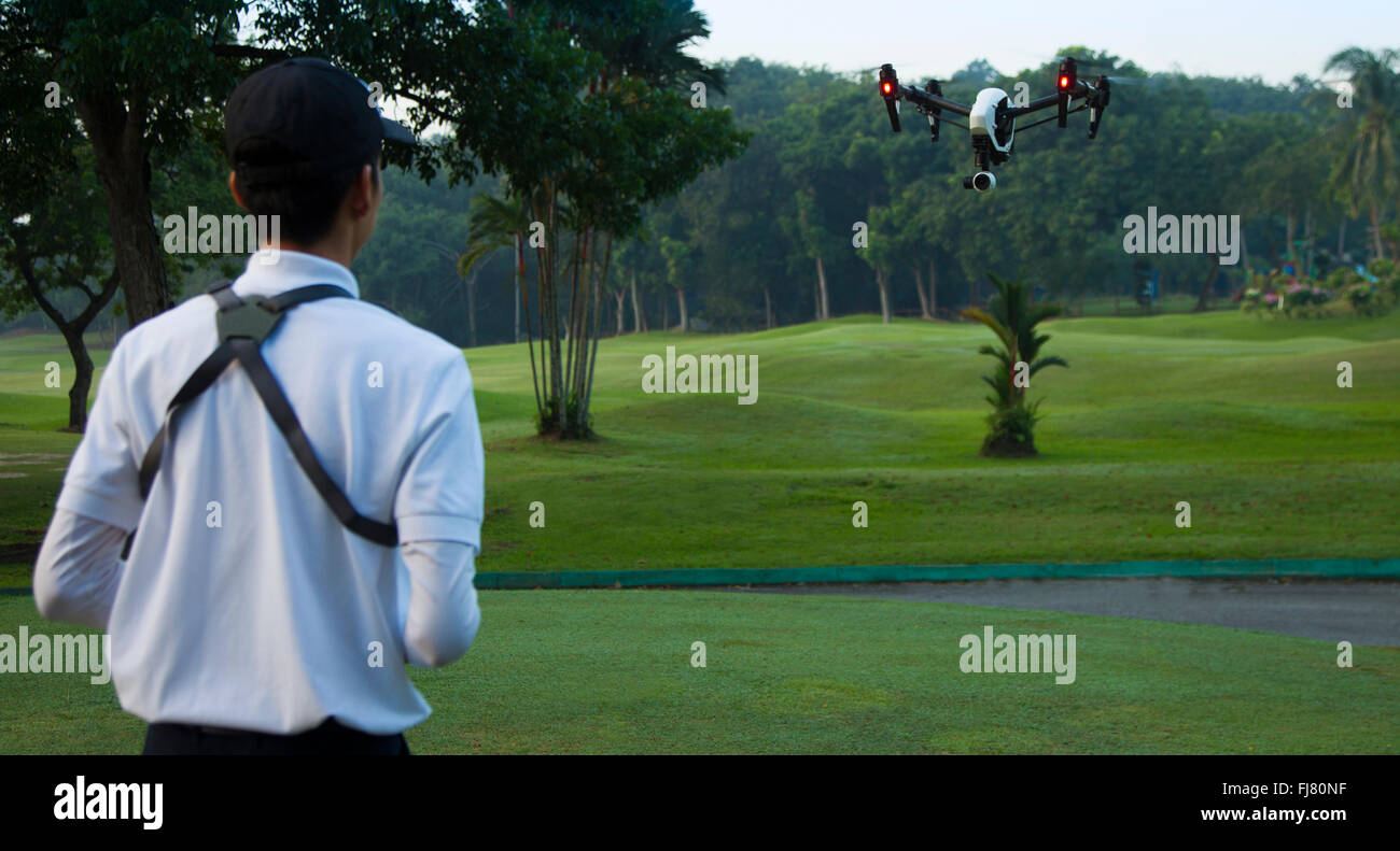Les hommes asiatiques aux commandes d'un drone dans un parc Banque D'Images