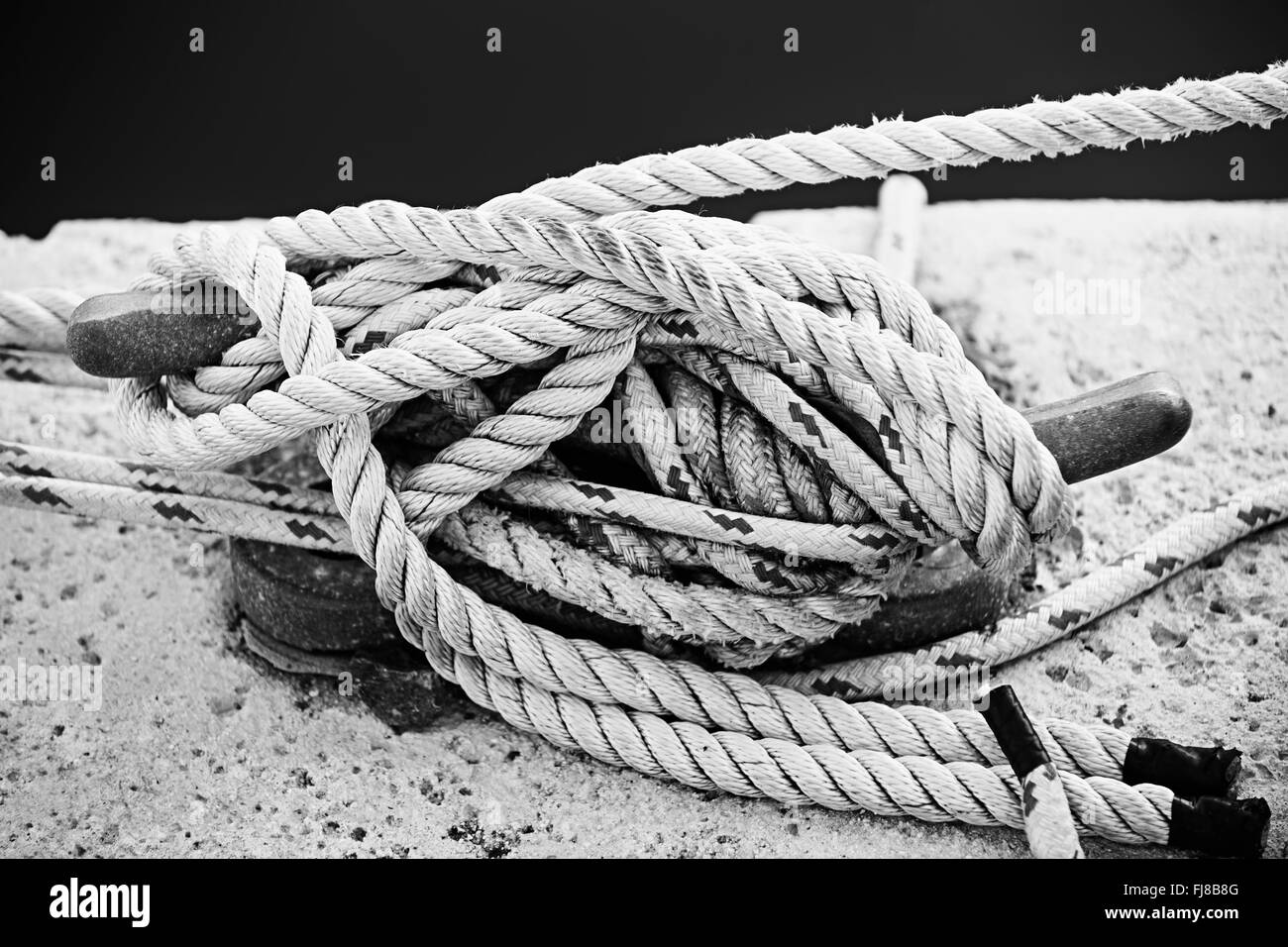 Cordes nautiques attachée autour de corne taquet sur le dock, Close up en noir et blanc. Le port de Key West, en Floride. Banque D'Images