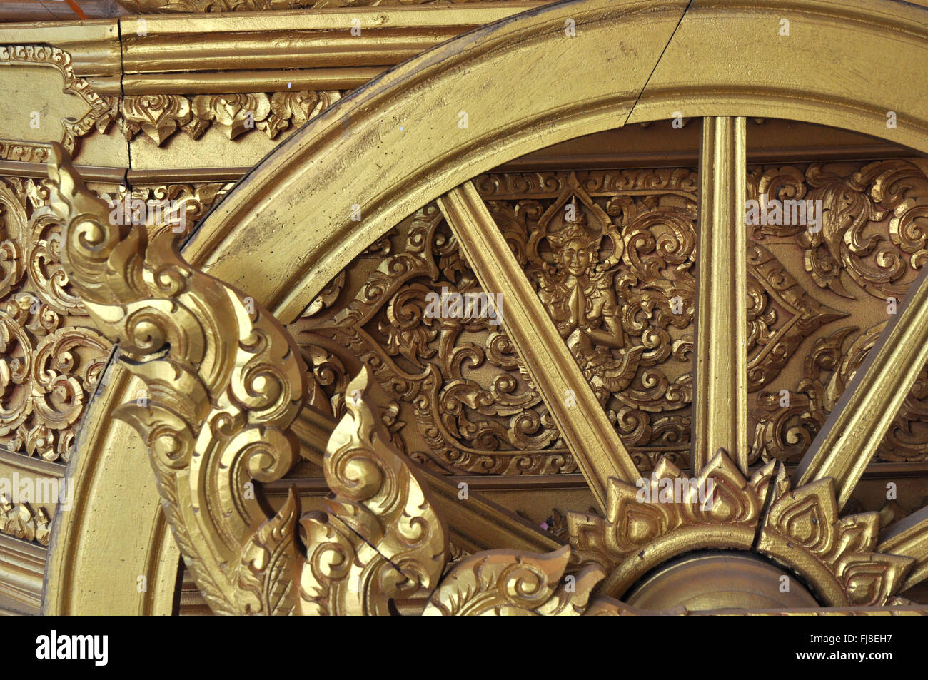 Détail : Roue de chariot d'or richement orné, temple bouddhiste, Luang Prabang, Laos Banque D'Images