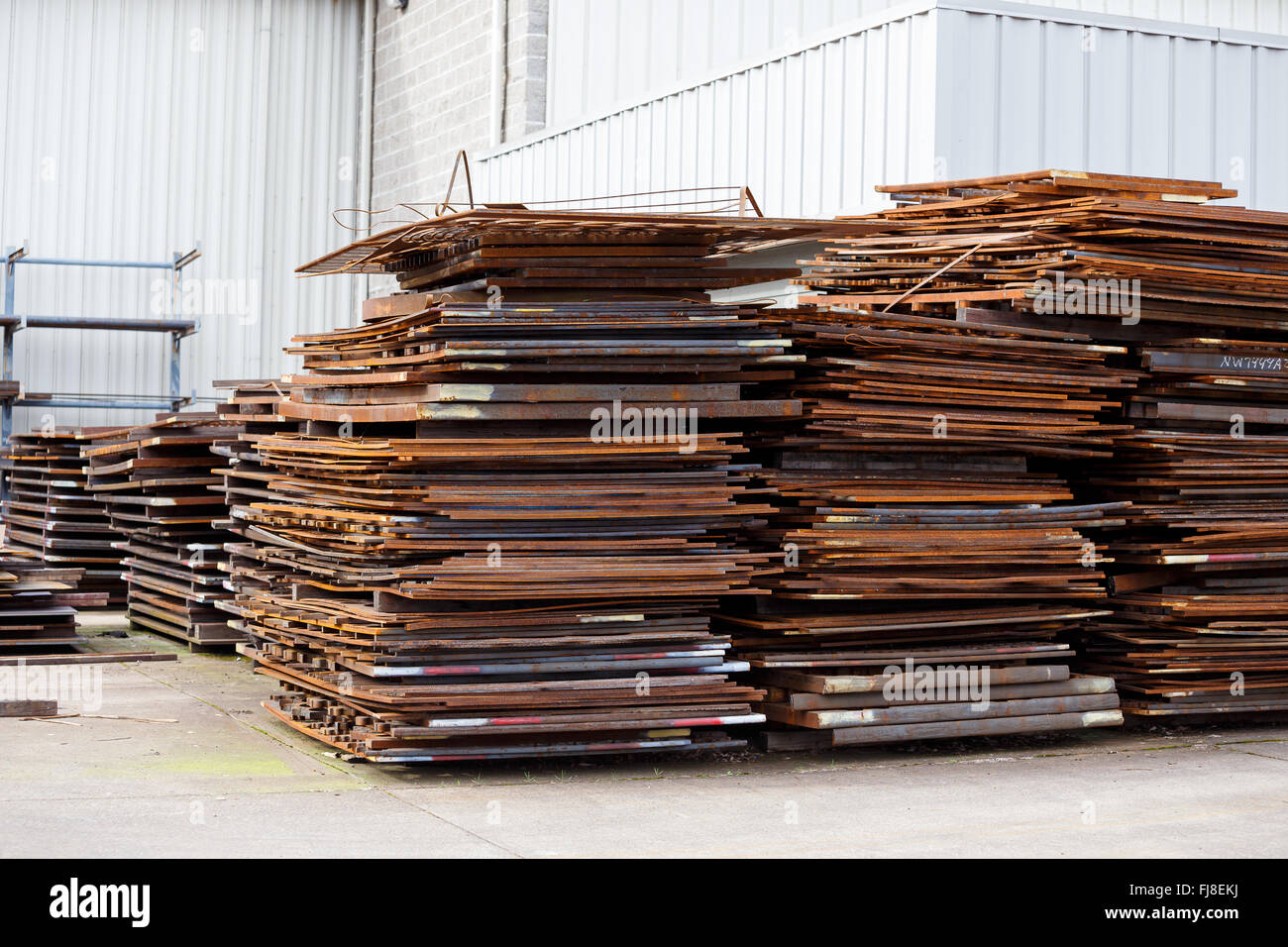 Les feuilles de métal ou fer à repasser en piles à un chantier prêt pour un projet de fabrication. Banque D'Images