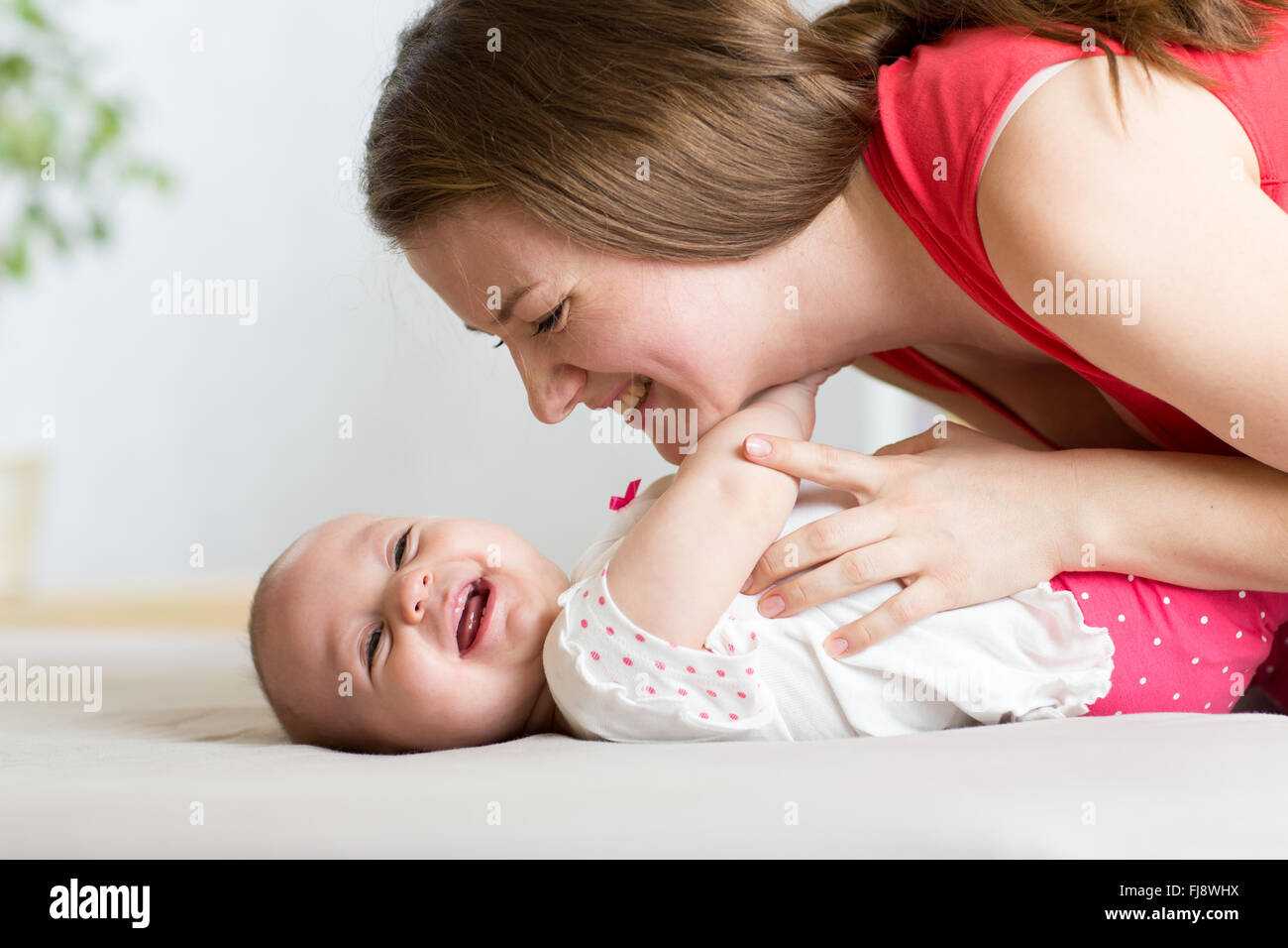 Smiling baby avec la mère à la maison Banque D'Images