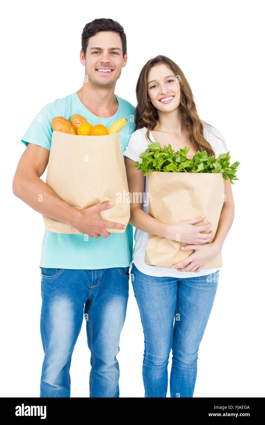 Heureux couple transportant des sacs d'épicerie Banque D'Images